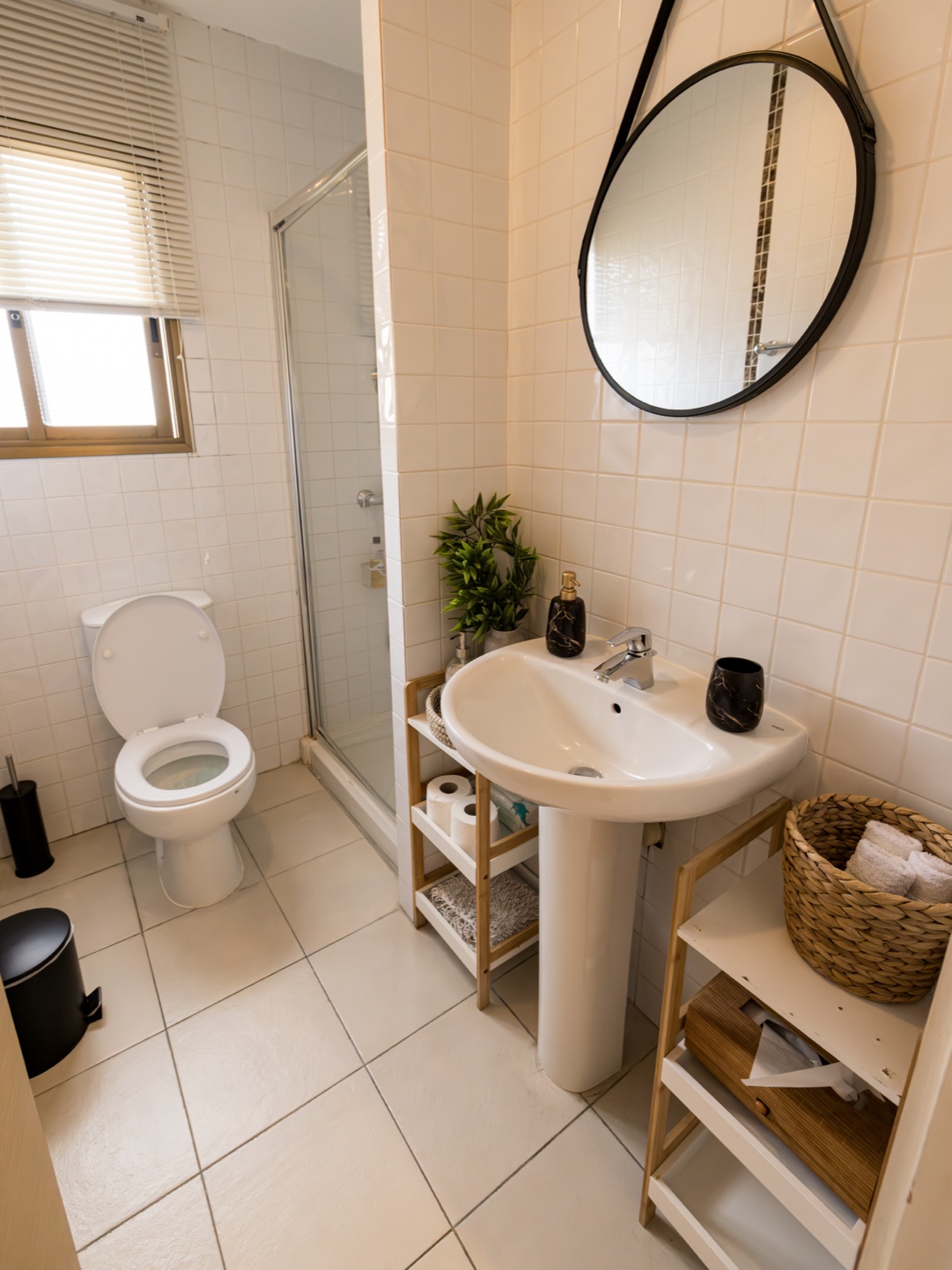 Clean bathroom with shower and round mirror